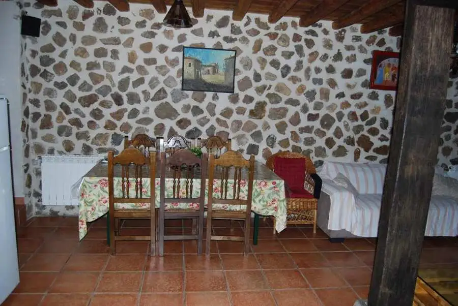 Comedor con pared de piedra en alojamiento rural Ávila
