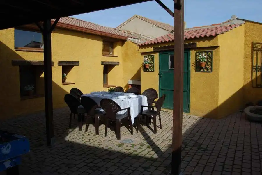 Mesa bajo pérgola en patio de alojamiento rural Ávila